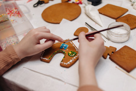 kids making gingerbread men and gingerbread house during the holidaysの写真素材