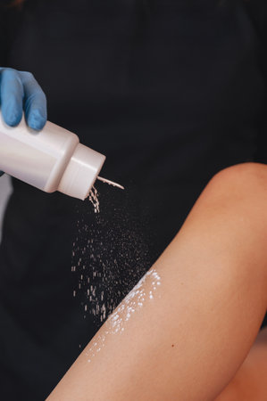 Beautician is removing hair from young female armpits with hot wax. Woman has a beauty treament procedure. Depilation, epilation, skin and health care conceptsの写真素材