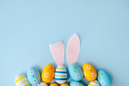 Easter poster. Blue, yellow and white Easter eggs on a light blue background. Top view. Flat lay.