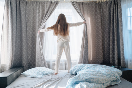 A girl with long hair enjoys a peaceful awakening early in the morning. High quality photoの写真素材