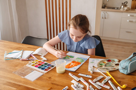 Cute little girl paints with paints.の写真素材