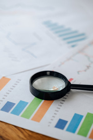 Business graphs, charts and magnifying glass on table, financial development concept.の写真素材