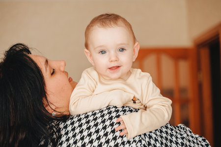 Mom holding baby in her arms, tender motherhood concept.の写真素材