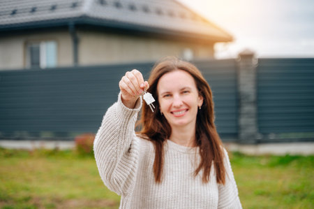 Happy woman with house keys, new real estate purchase.の写真素材
