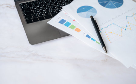 Business documents and charts on desk with laptop background, analytics concept.の写真素材