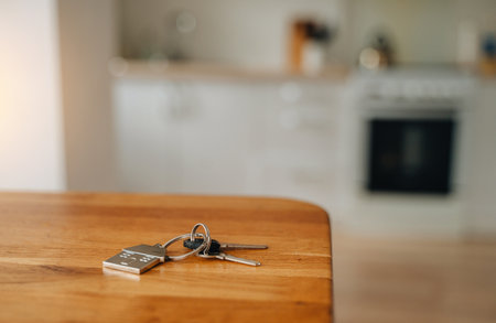 House keys with keychain lying on wooden table, real estate concept.の写真素材