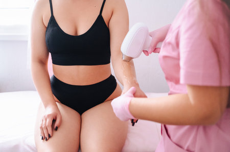 Specialist performing laser hair removal on girl's arms in salon.の写真素材