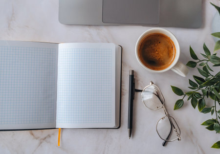 Blank notepad with laptop and coffee cup on desk, workspace template.