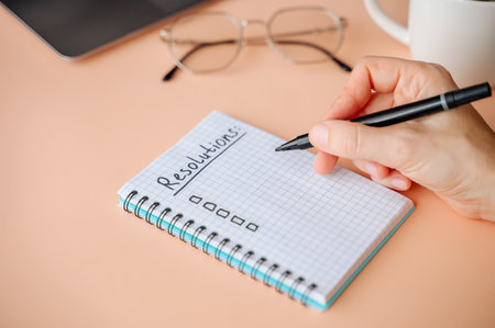New Years Resolutions written in a notebook with plans for future goals and self-improvement.