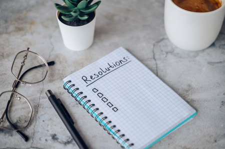 New Years Resolutions written in a notebook with plans for future goals and self-improvement.の写真素材
