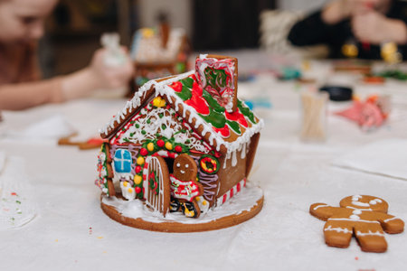 Children decorating gingerbread house with icing and candy, Christmas fun activity.の写真素材