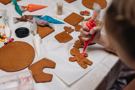 Children decorating gingerbread house with icing and candy, Christmas fun activity.の写真素材