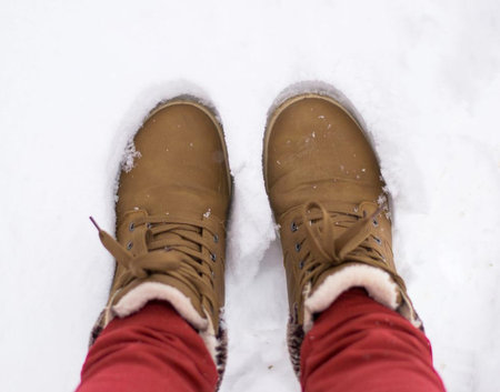 brown boots standing on snow in winter, top view. High quality photo