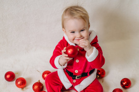 Cute little girl holding Christmas baubles, festive holiday portrait.の写真素材