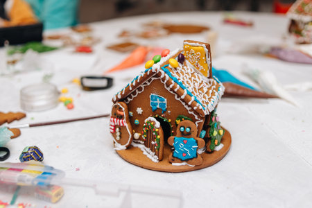Children happily decorating gingerbread houses with icing and candy for a festive Christmas holiday activity.の写真素材