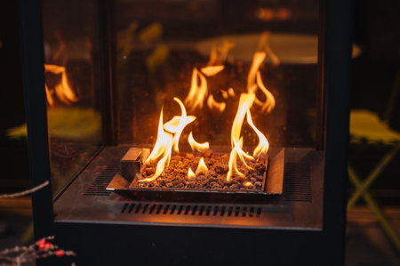 Burning fire in a cozy outdoor cafe in winter, creating a warm and inviting seasonal atmosphere for guestsの写真素材