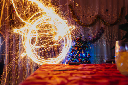 Abstract circles of sparklers forming light trails in a room, symbolizing festivity and caution concept.の写真素材