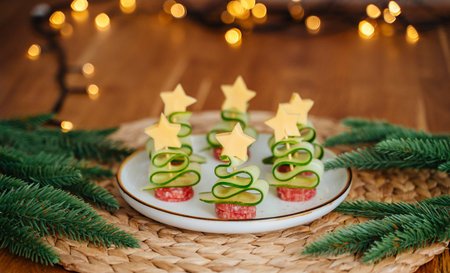 Festive New Year canape shaped like trees and stars with fir branches and lightsの写真素材