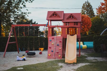 Empty beautiful modern playground with swings and a slide in the park Children outdoor activities concept.の写真素材