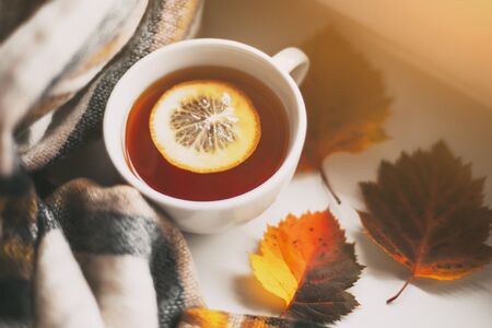 autumn cup of tea with lemon, yellow autumn leaves and plaid 1の写真素材
