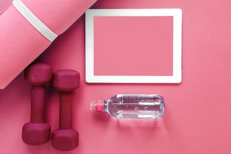 flatlay pink: tablet, sports mat, dumbbells and a bottle of water