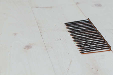 flat lay metal thin nails on a light wooden background, place for text, construction concept 1の写真素材