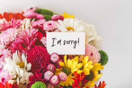 bright multi-colored bouquet of flowers with white card with the inscription i am sorry, the concept of apologies.の写真素材