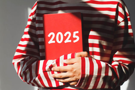 One girl, whose face is not visible in a striped red long sleeve, holds a red diary with the...