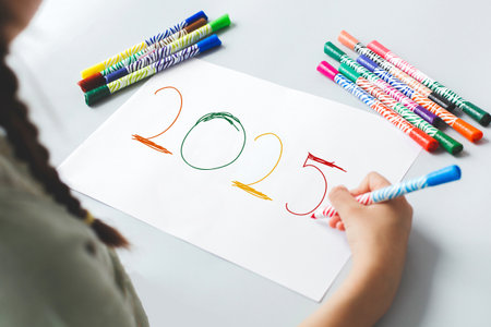 white sheet of paper, the child draws with felt-tip pens number 2025, concept the new yearの写真素材