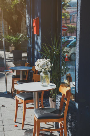 street cafe on a sunny warm day, a bouquet of beautiful white flowers on the table, vertical photo.の写真素材