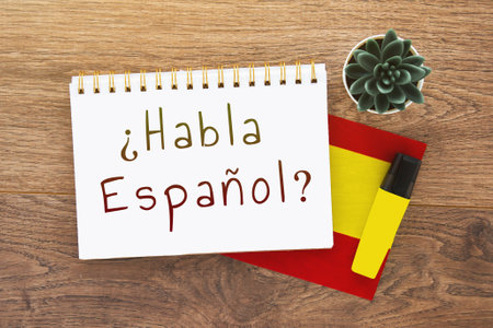 notebook with description do you speak spanish on spanish, pen, spain flag, marker on wooden brown desktopの写真素材