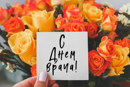 bright bouquet of orange yellow roses and white cardboard card with the inscription Happy Doctor's...