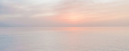 Peaceful seascape with a soft pastel sunset over calm ocean waters, creating a tranquil and dreamy atmosphere.1の写真素材