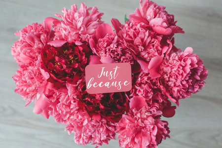 Beautiful bouquet of pink and red peonies with a small card that says just because , symbolizing care, spontaneity, and affection, perfect for greeting cards, floral design, or romantic gift conceptsの写真素材