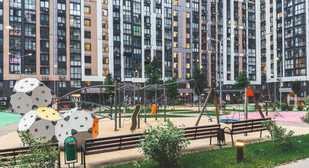 Modern residential courtyard with children s playground including climbing structures, swings and...