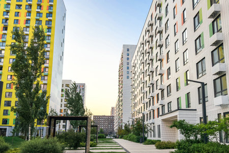 Modern colorful apartment buildings with balconies and green courtyard, representing urban architecture, residential development, and comfortable city living with eco-friendly designの写真素材