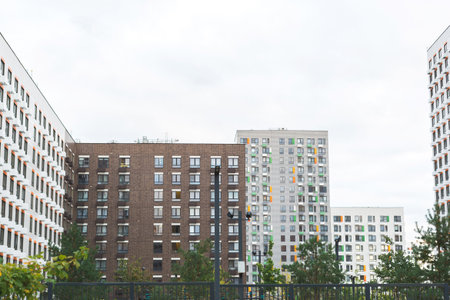 Modern residential buildings with geometric facades and colorful window accents, surrounded by...