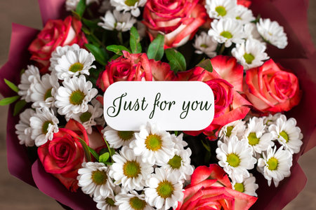 Beautiful bouquet red roses and white daisies with greeting card that reads just for you, symbolizing love, care, celebration, appreciation a perfect floral gift for special occasions romantic momentsの写真素材