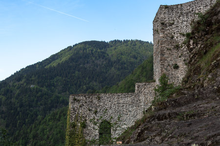 Ancient stone fortress on a rocky slope surrounded by lush green mountains under a clear blue sky, historical Zilkale castle in the Black Sea region of Turkey, concept of heritage and travelの写真素材