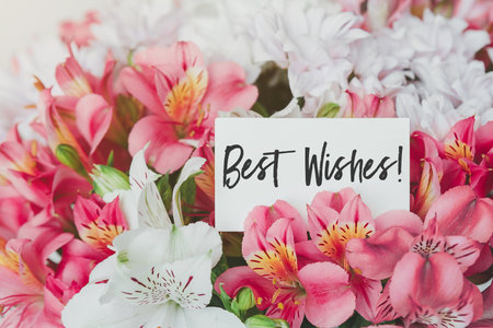 Bright beautiful bouquet of alstroemerias and chrysanthemums with gift card with the inscription best wishes.の写真素材