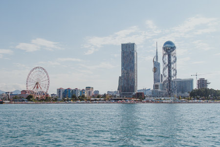 08.2022, Batumi, Georgia: View of the Batumi embankment from the sea on a hot summer day, Ferris wheel, alphabet tower, beachesの写真素材
