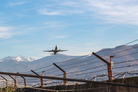 Passenger airplane taking off from Batumi airport over mountain landscape on clear day, commercial...