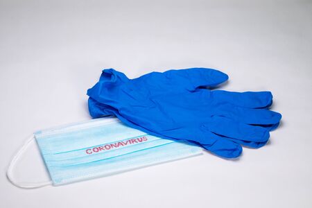 COVID-19. Facial masks on the pile. Epidemic background. Sterile disposable medical blue gloves lie...