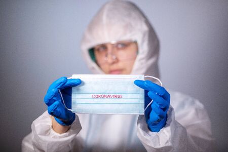 COVID-19. 2019 Novel Coronavirus (2019-nCoV) concept. Young girl doctor in a white protective...