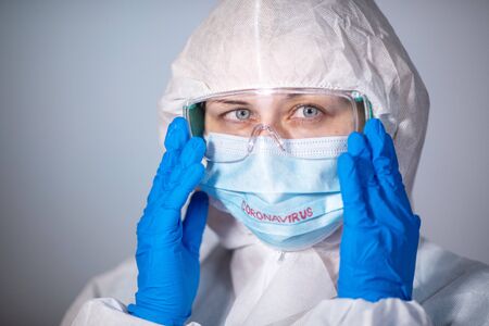 COVID-19. 2019 Novel Coronavirus (2019-nCoV) concept. Young girl doctor in a white protective coat...