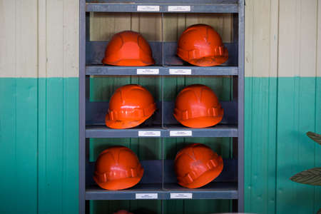 Orange safety helmets lie on a shelf.のeditorial素材