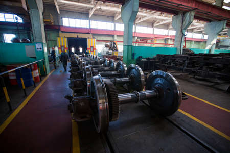 Axles with wheels of railway cars lie in a row at a repair plantのeditorial素材