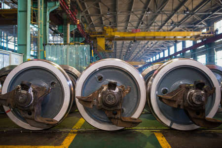 Axles with wheels of railway cars lie in a row at a repair plantのeditorial素材