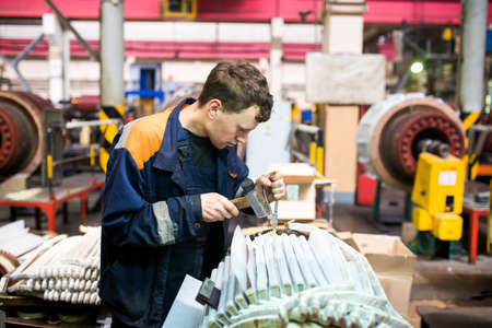 Summer, 2016 - Ussuriysk, Primorsky Krai - Ussuriysky Locomotive Repair Plant. Workers stand behind the machines at the factory and work.のeditorial素材
