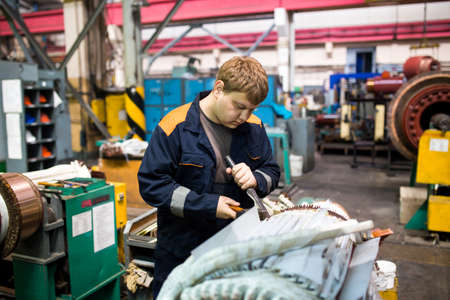 Summer, 2016 - Ussuriysk, Primorsky Krai - Ussuriysky Locomotive Repair Plant. Workers stand behind...